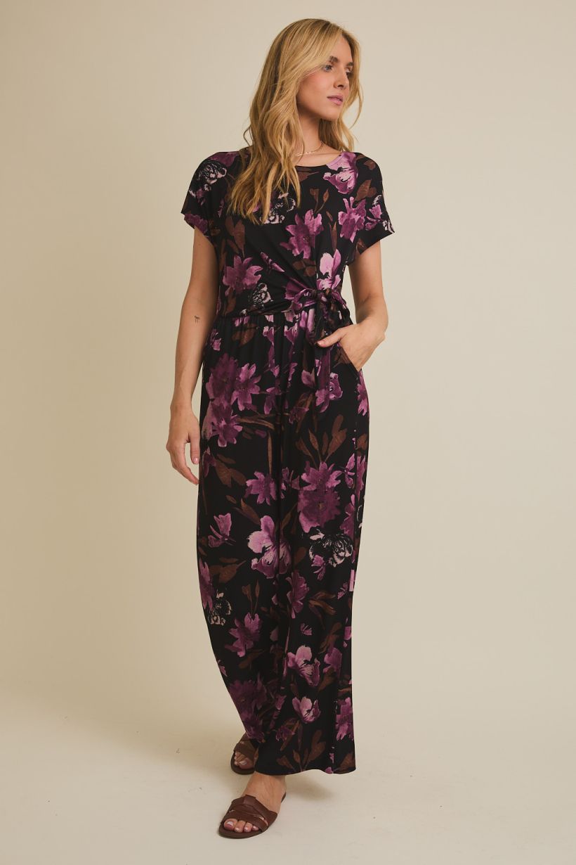 black jumpsuit with floral pattern and boat neckline