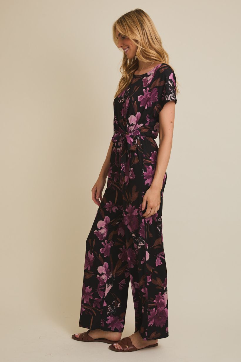 black jumpsuit with floral pattern and boat neckline