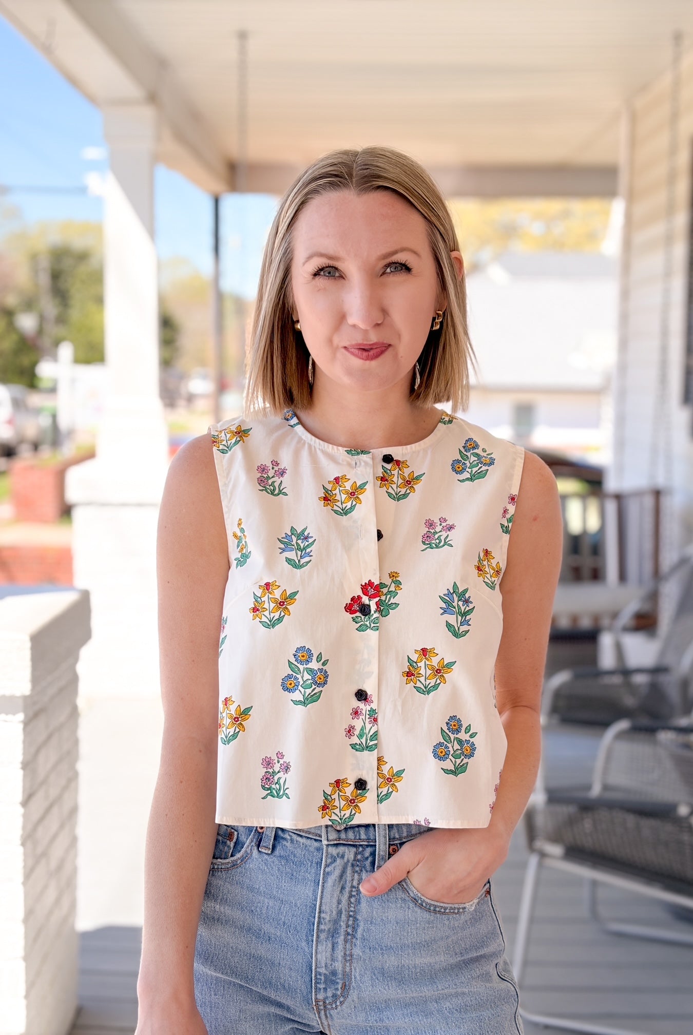 cream sleeveless top with floral pattern, button up front