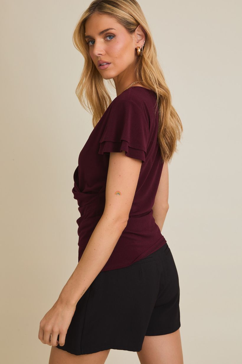 wine colored short sleeve top with v neckline and faux wrap detailing