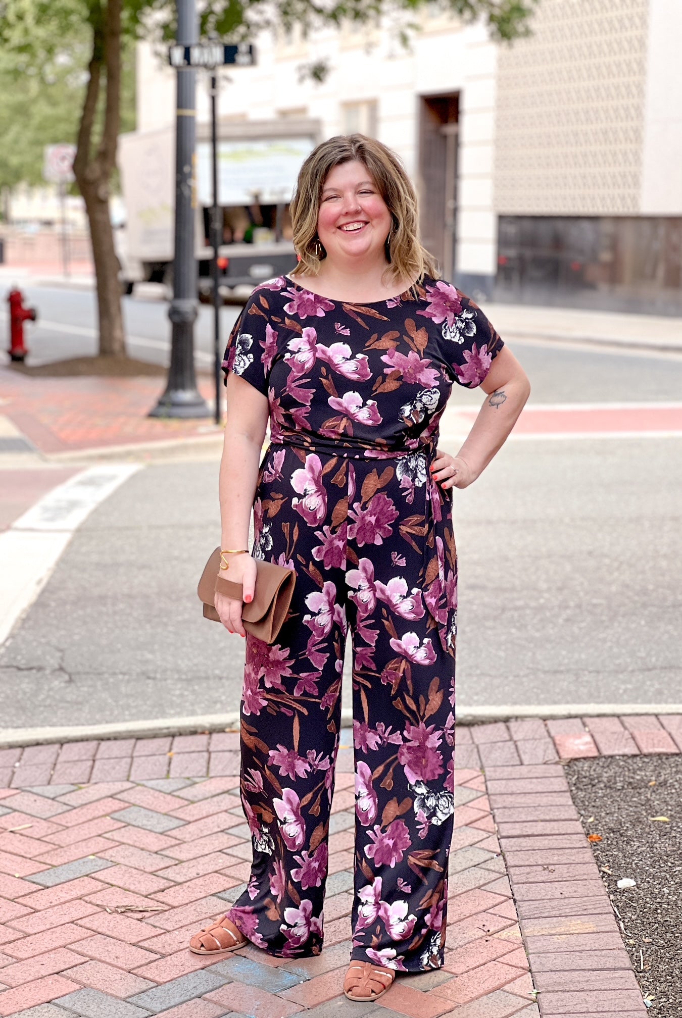 black jumpsuit with floral pattern and boat neckline