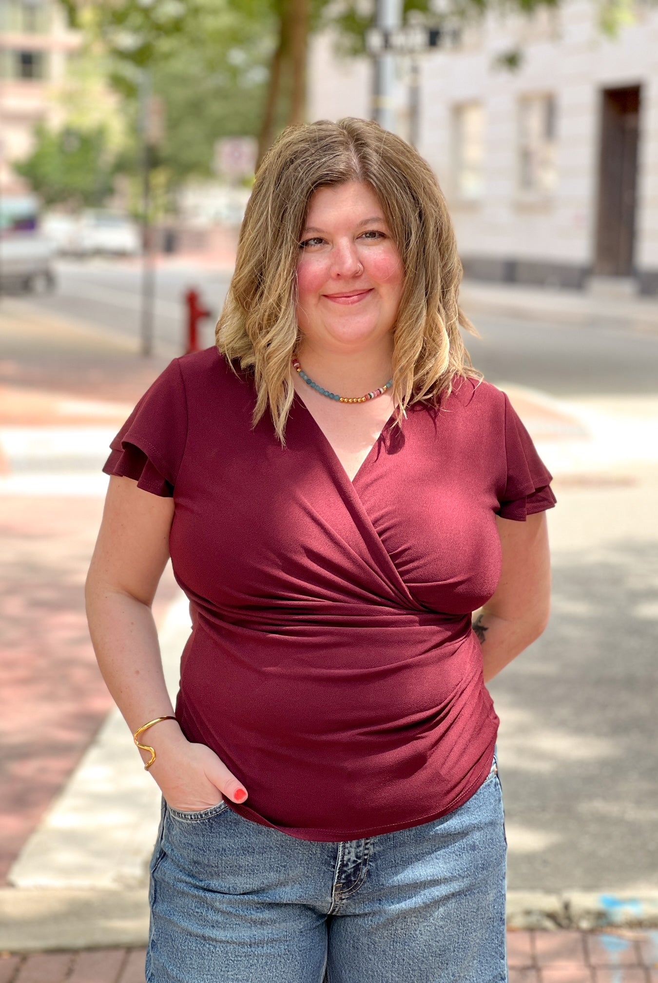 wine colored short sleeve top with v neckline and faux wrap detailing