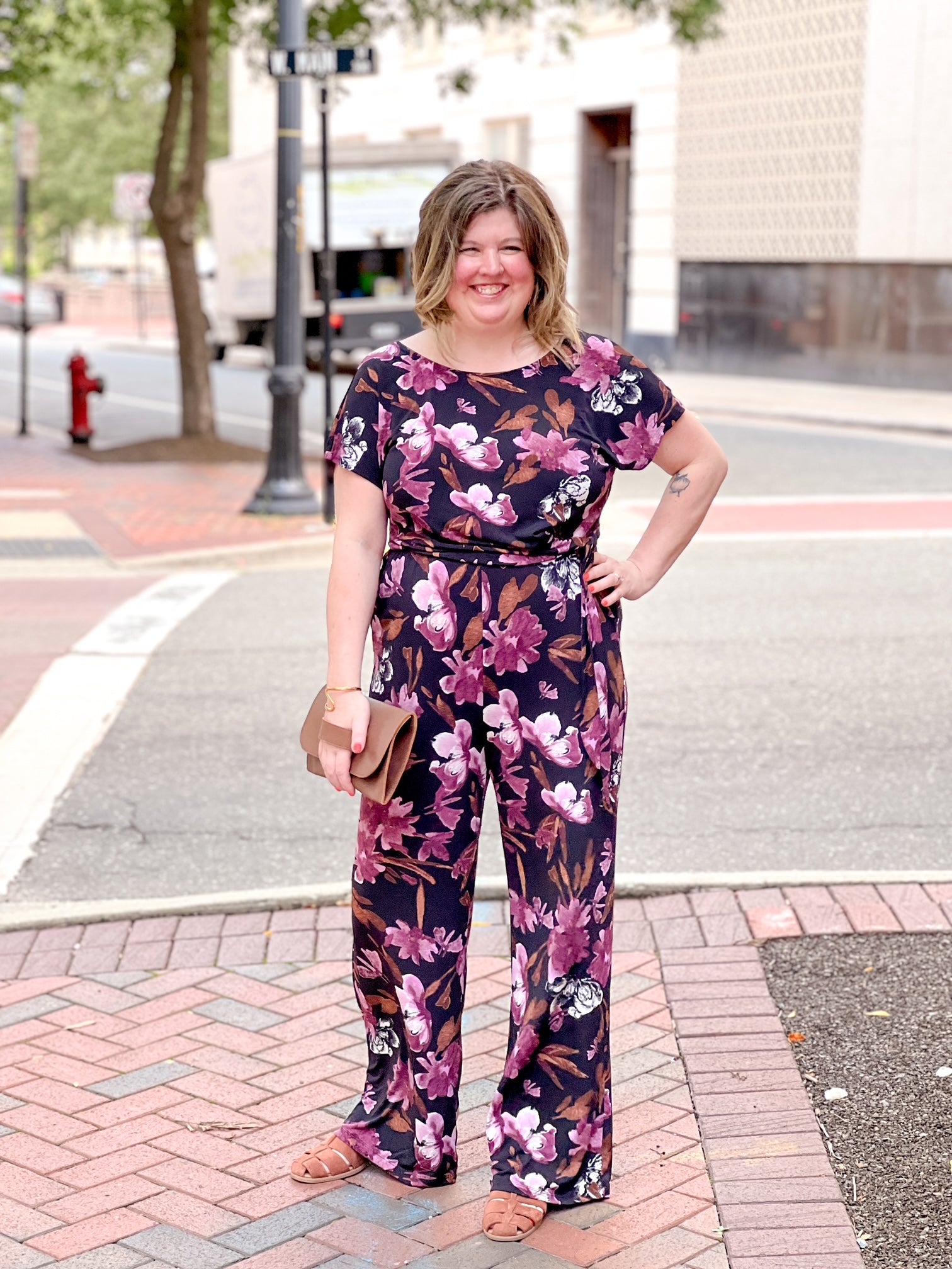 black jumpsuit with floral pattern and boat neckline