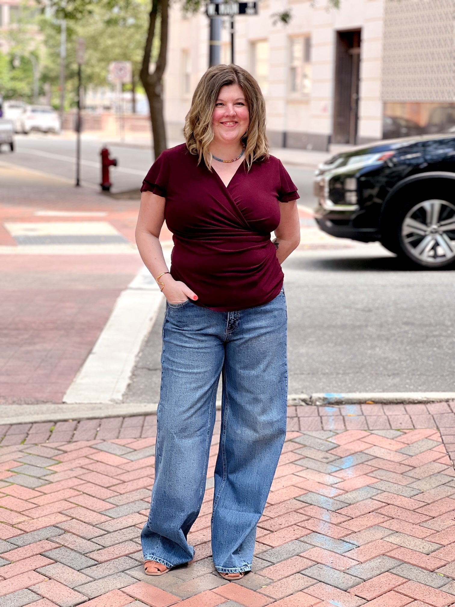 wine colored short sleeve top with v neckline and faux wrap detailing