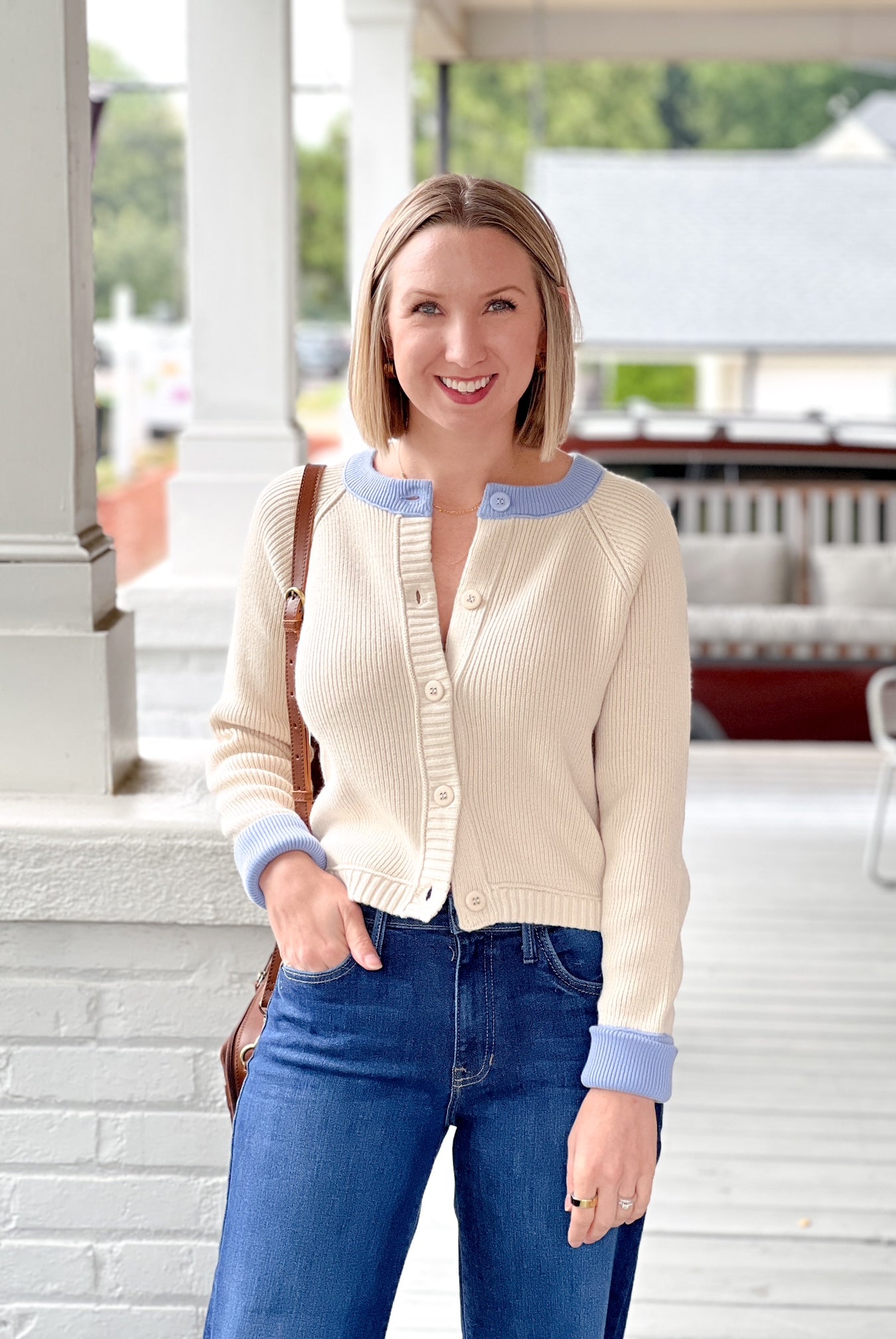 cream button up sweater with light blue lining on neckline and sleeves