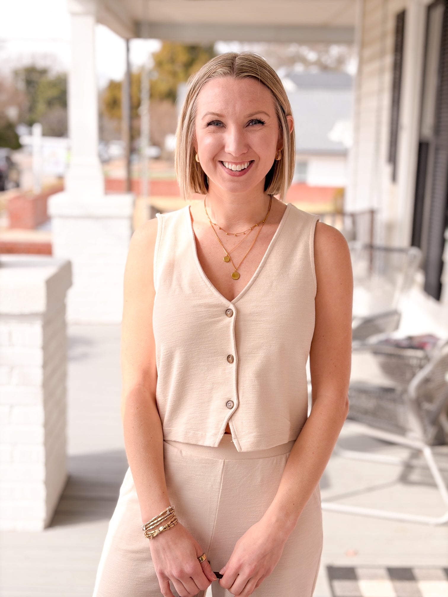 white sleeveless top with v neckline and buttons