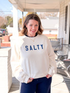 white sweatshirt that says "Salty" in blue letters