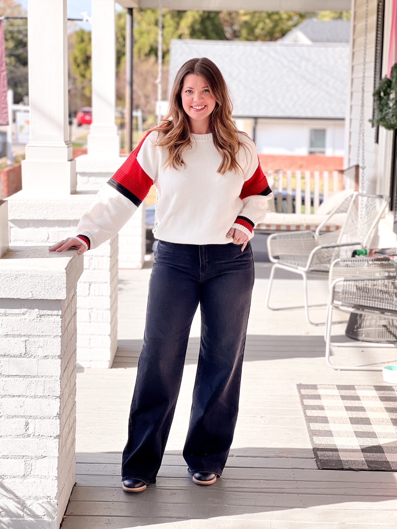 white sweater with red and black stripes on sleeves
