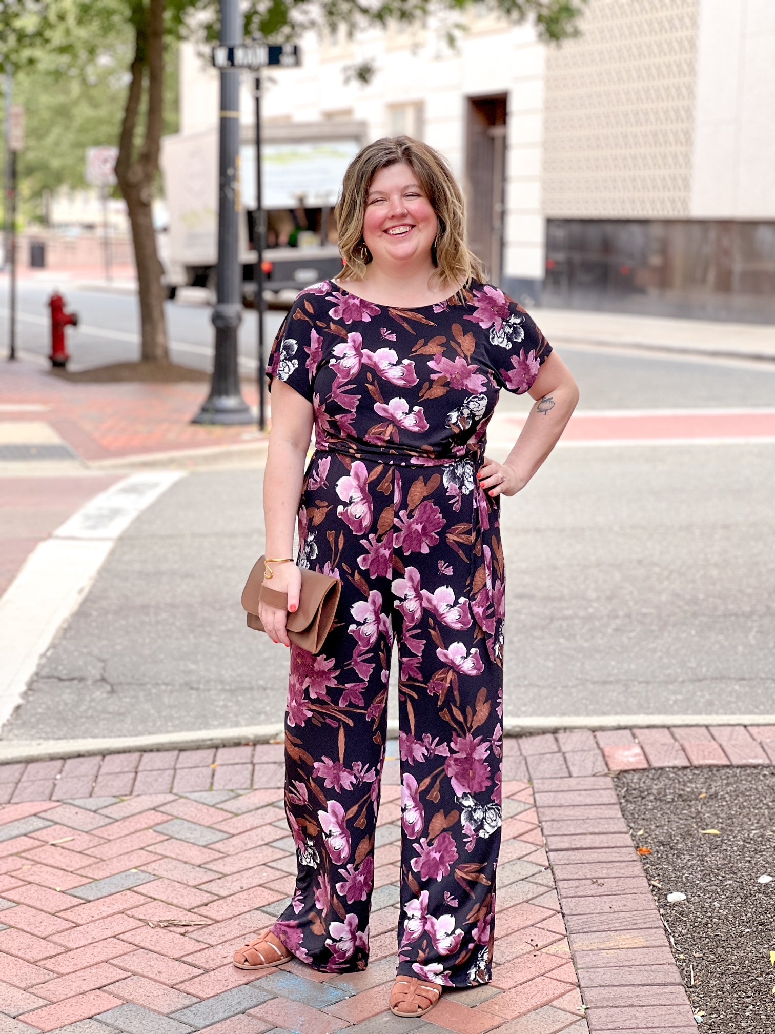 black jumpsuit with floral pattern and boat neckline