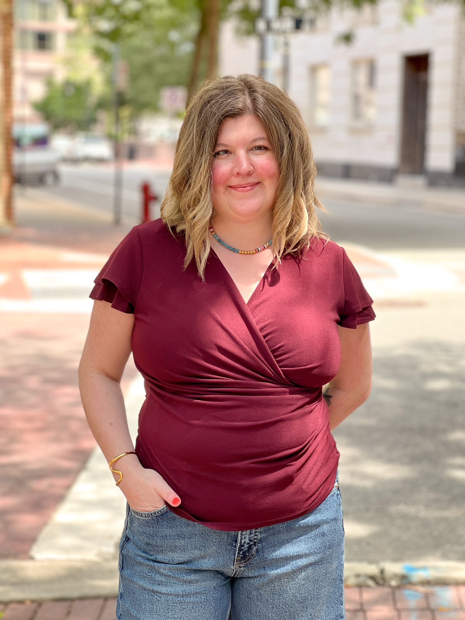 wine colored short sleeve top with v neckline and faux wrap detailing
