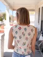 cream sleeveless top with floral pattern, button up front