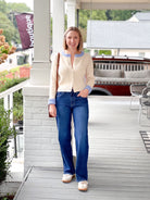 cream button up sweater with light blue lining on neckline and sleeves