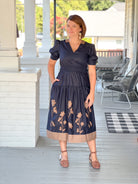 midi length dark navy dress with brown floral design and v neckline