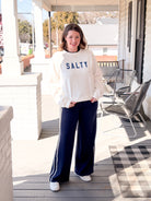 white sweatshirt that says "Salty" in blue letters