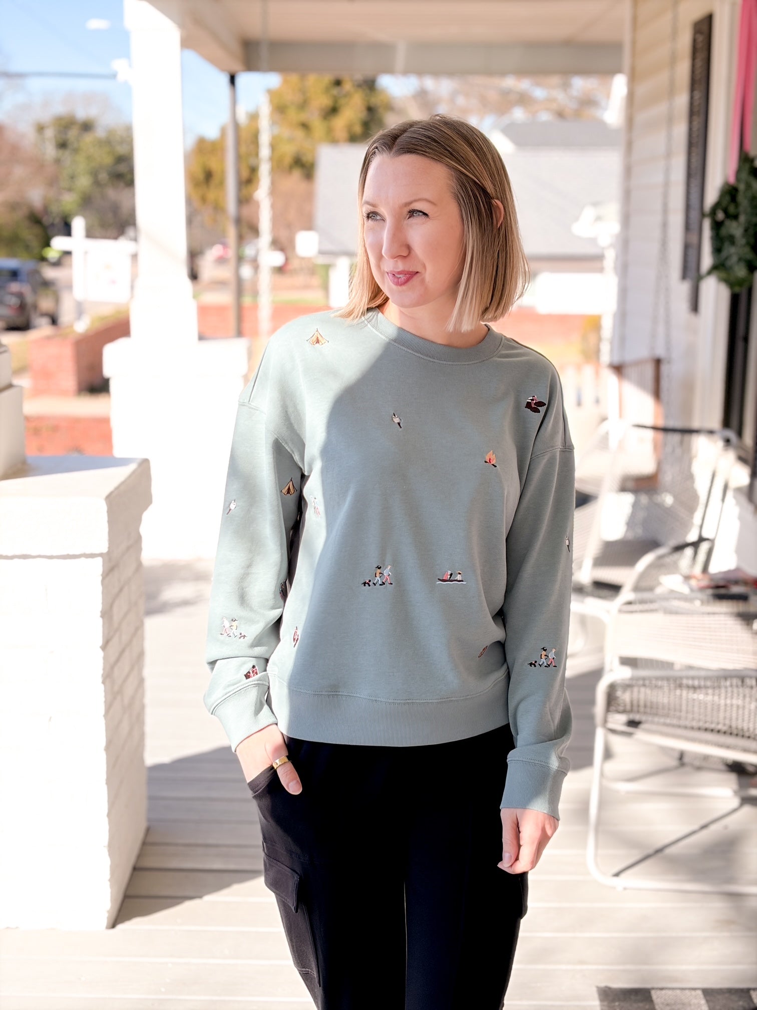 teal blue sweatshirts with small camping patterns sewn on