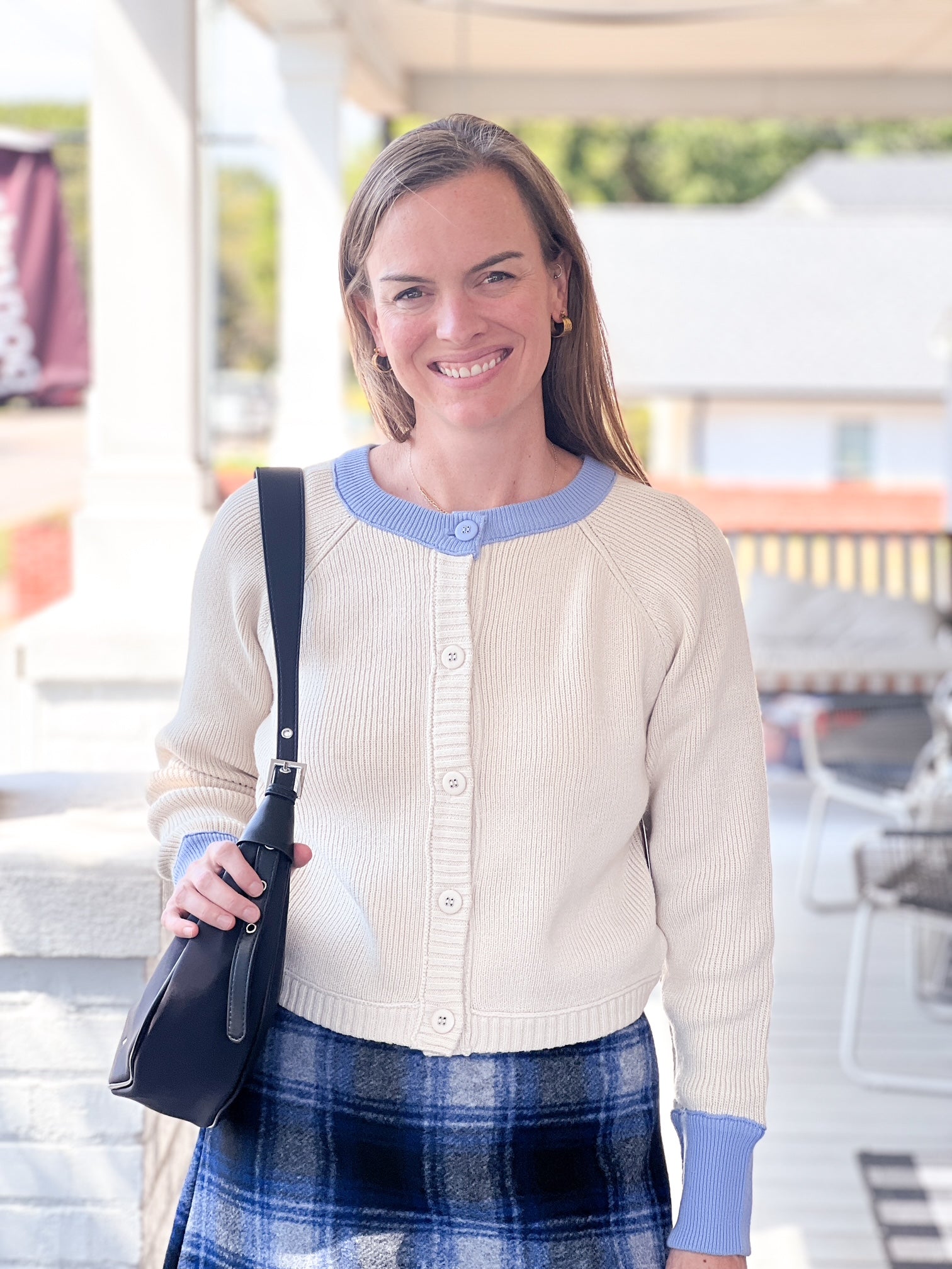cream button up sweater with light blue lining on neckline and sleeves