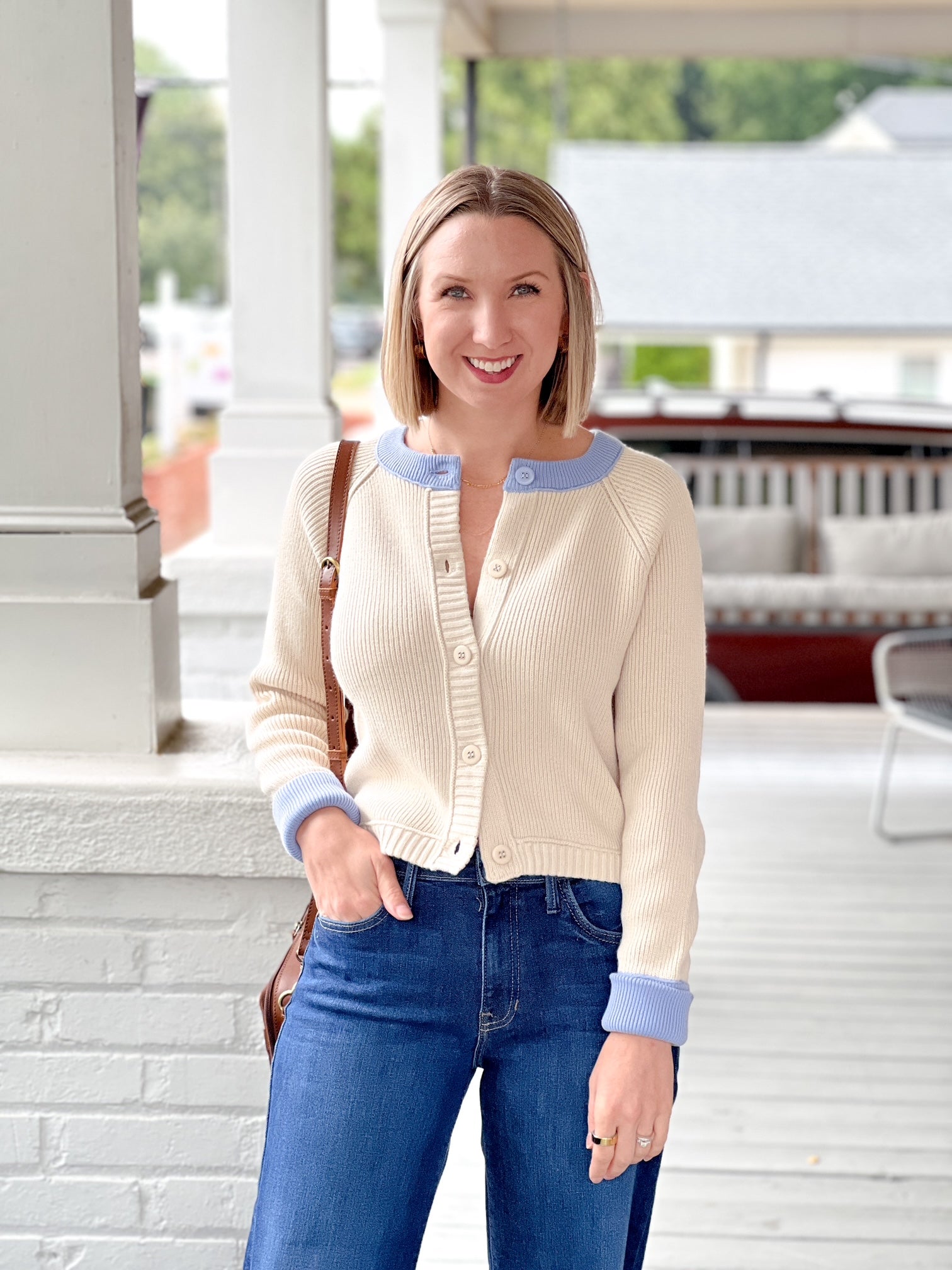 cream button up sweater with light blue lining on neckline and sleeves