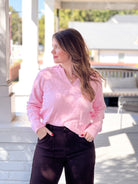 long sleeve pink sweater with collared neckline and checkered pattern